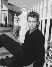Cal Trask Sits On The Ground Leaning On A Picket Fence In A Publicity PHOTO