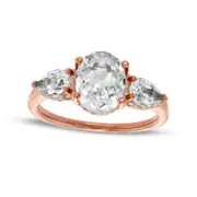 Oval White Lab-Created Sapphire and 0.17 CT. T.W. Diamond Frame Three Stone Engagement Ring in Solid 10K Rose Gold
