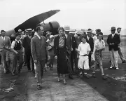 Aviator Amelia Earhart with a group of people at an airfield 1932 Photo Print