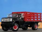 1/64 DCP BLACK/RED GMC 6500 SINGLE AXLE STAKE BED