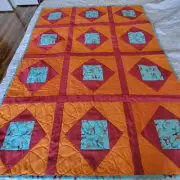 Handmade Orange and Teal Childs Quilt which measures approximately 51 by 38 inch