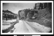 Road leading into Bryce Canyon Park with a vehicle passing through - Old Photo