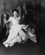 English actress Joan Collins riding a swing whilst wearing a ball - Old Photo