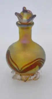 Gold Luster Perfume Bottle With Red Wave Design. Saul Alcaraz