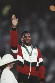 Trinidad Tobago athlete Ato Boldon raises one arm in the air in ce- Old Photo