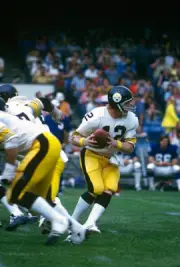 Quarterback Terry Bradshaw Pittsburgh Steelers turns to hand the - 1976 Photo