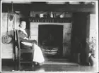 Women sitting in a chair by hearth at the Tolstoy Settlement OLD PHOTO