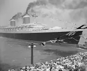Rugged tugboat pushes sleek new super liner SS United States out in- 1952 Photo