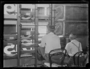 Two men changing the numbers inside the scoring board at the Sydne- Old Photo