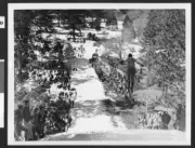 Ski jumper perused by a crowd of spectators on either side of the - Old Photo