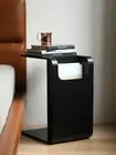 Black/Walnut/Natural oak Side Table slotted over the seat of a sofa Books