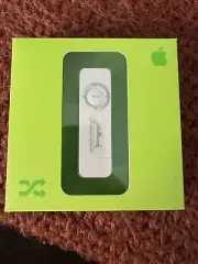 1st Gen Apple IPod Shuffle 512GB. Open box Appears Unused. John Hancock Logo