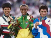 Gold medalist Fatuma Roba of Ethiopia stands on the podium with si- Old Photo