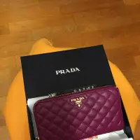 在飛比找蝦皮購物優惠-PRADA 經典浮雕LOGO皮革壓菱格紋拉鍊長夾(紫)