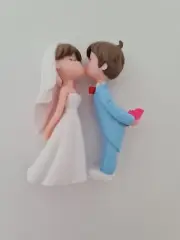 Cute bride and groom kissing wedding cake topper