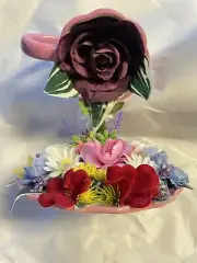 A flying lila cup with a purple rose enjoy the view of a beautiful flower Garden