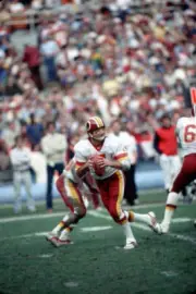 Quarterback Joe Theismann of the Washington Redskins drops back - 1983 Photo 1