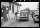 Unloading milk cans at cooperative creamery which has received a l - Old Photo