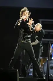 Mick Jagger onstage as a roadie adjusts his microphone at San Siro- Old Photo