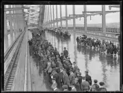 Crowds of people walking across Sydney Harbour Bridge in the rain - Old Photo