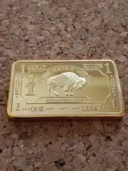 24K GOLD PLATED REPLICA 1 TROY OUNCE GOLD BULLION BAR IN DISPLAY CASE.