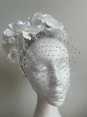 White flower fascinator with silver netting on a headband