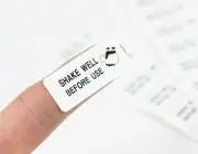 "Shake well before use" labels / sticker. 38mm x 16mm, white label black print.