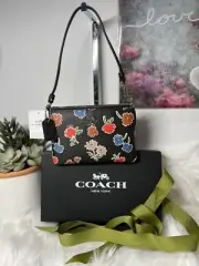 New with tag Coach wristlet with multi color daisy print.