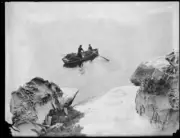 Two prawn fishermen in a boat beneath a rocky cliff, NSW, 1930 Old Photo