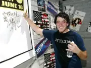 Finch bassist Derek Doherty poses while signing a poster backstage - Old Photo