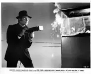 Ryan O'Neal as Webster McGee fires a gun in a scene from the Warne- Old Photo