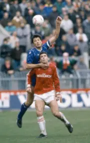 Joe McLaughlin of Chelsea heads the ball above Andy Jones of Char - Old Photo