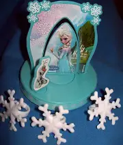 DISNEY FROZEN PARTY CAKE TOPPER AND THREE SMALL SNOWFLAKE RINGS.