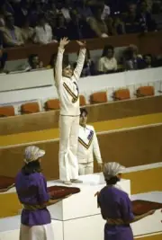 Nadia Comaneci victorious with gold medal on stand after winning v- Old Photo