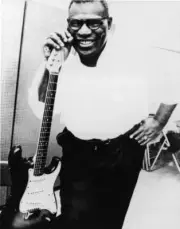 blues singer songwriter Howlin' Wolf smiling beside an electric gu- Old Photo