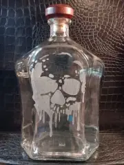 750 ML glass whiskey bottle with reusable cork top and glass etched skull