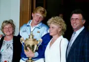 Boris Becker of West Germany with the trophy, surrounded by his f - Old Photo