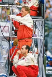 Dan Gurney keeps an eye on the time as Juan Manuel Fangio II sits - Old Photo