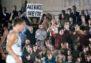Kenyon fan in stands holding sign that reads ALL BIRDS ARE FOUL du- Old Photo