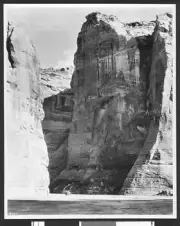 View of cliffs showing a parked automobile or wagon at their base - Old Photo