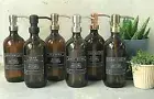 Amber glass bottle soap dispenser with metal pump and designer label decal