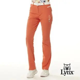【Lynx Golf】女款彈性舒適Lynx魔術方塊繡花拉鍊口袋配色透氣織帶剪接造型窄管長褲-橘色