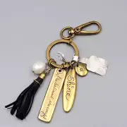 Chicos Keychain SHE BELIEVED SHE COULD Charm keychain Gold tone Black Tassel NWT