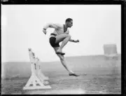 Athlete George Golding jumping over a hurdle whilst training for t- Old Photo