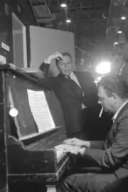 Frank Sinatra leaning on piano with composer Nelson Riddle during - Old Photo