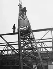 Worker climbing a crane to oil pulleys during the constructi - 1936 Old Photo 1