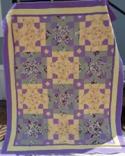 Handmade Purple, green and yellow quilt which measures approximately 82 by 66 in