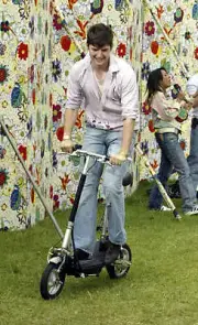 James Alexandrou rides a scooter backstage at 958 Capital FMs Par- 2004 Photo 2